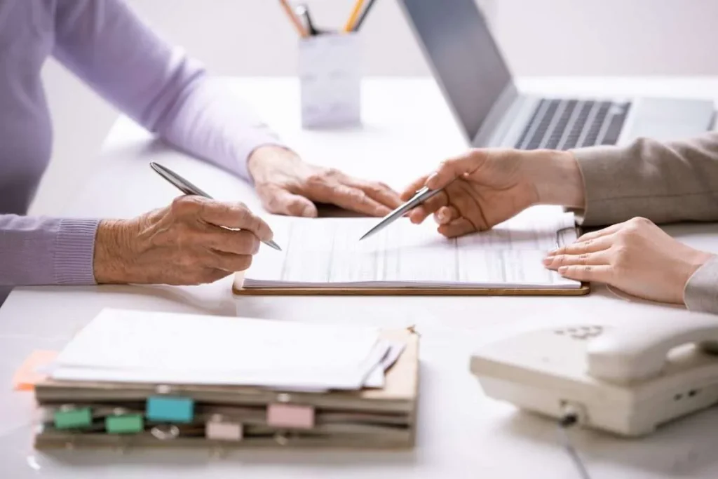 An insurance agent discusses policy paperwork with a client