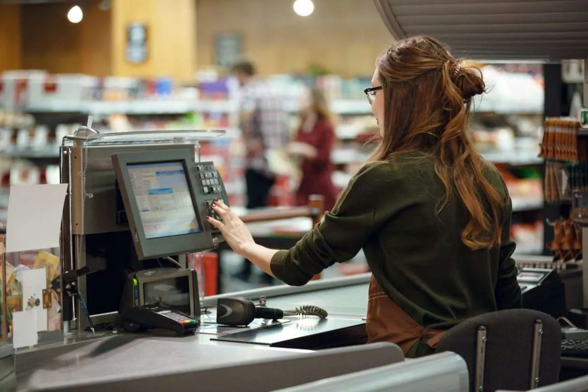 A cashier operates a POS at a New Orleans grocery store