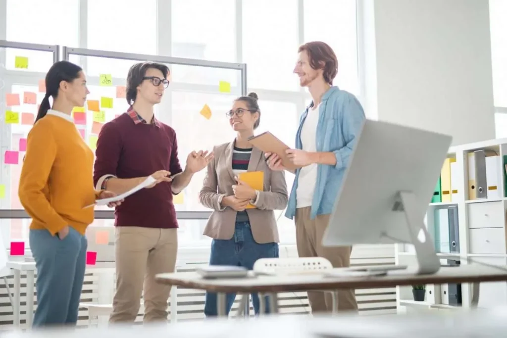 A group of employees discuss a project at work