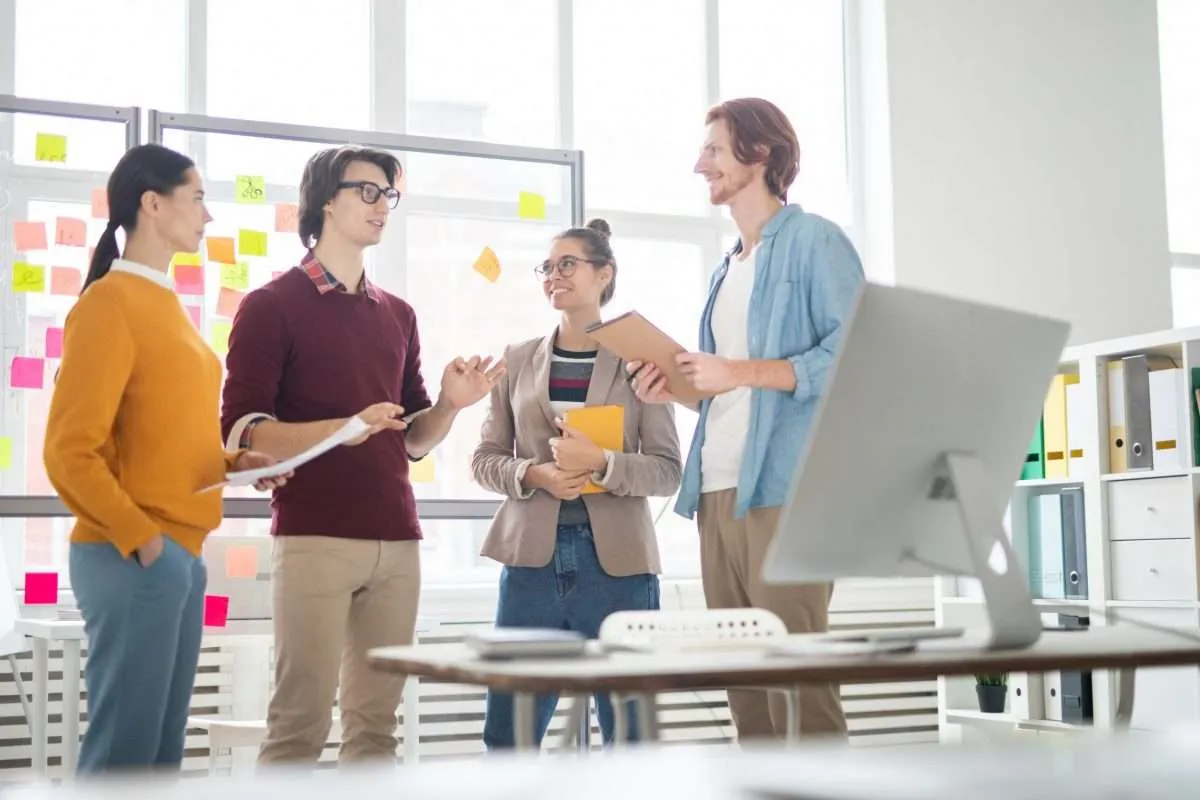 A group of employees discuss a project at work
